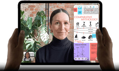 iPad Pro, Vorderansicht, Querformat, Farbe Space Schwarz, gerundete Ecken, schwarzer Displayrand, zwei Hände halten es an der linken und rechten Seite, das Display zeigt ein FaceTime Gespräch, das live übersetzt wird, und eine Lernapp zeigt eine Präsentation zum Thema „Vergleichende Mythologie“ mit Text, Diagrammen und handschriftlichen Notizen